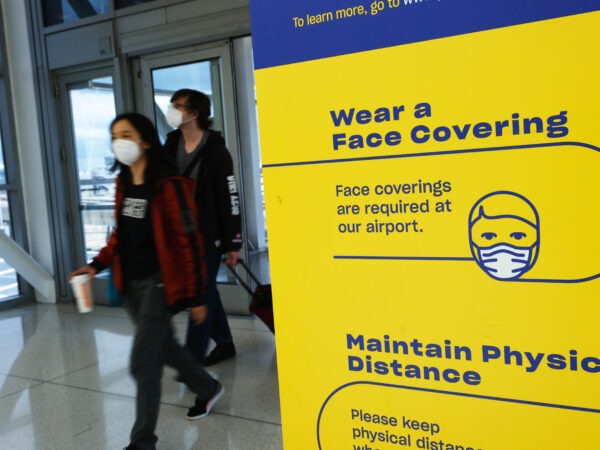 masked passengers entering an airport