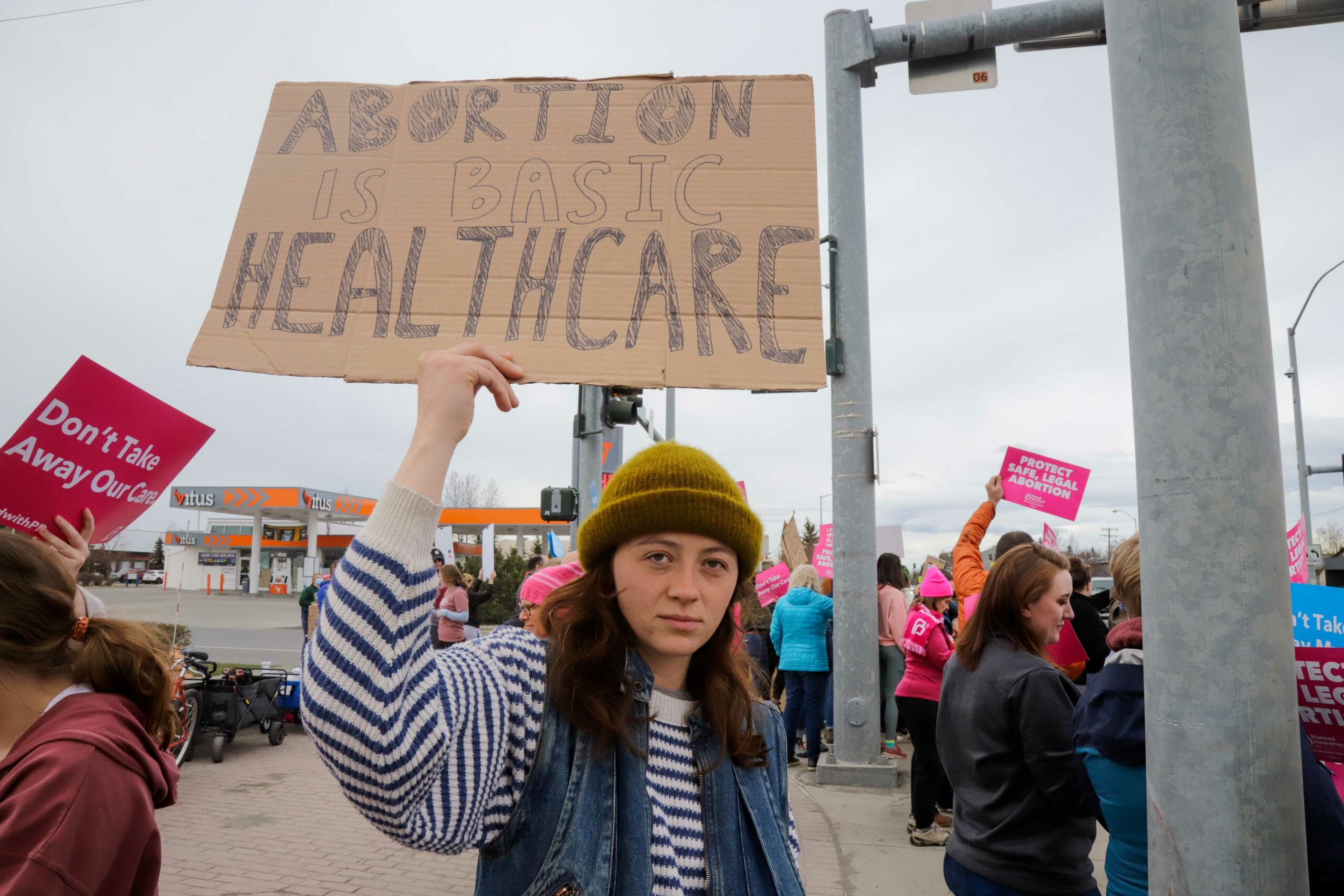 a person holds a sign that reads "abortion is basic healthcare"