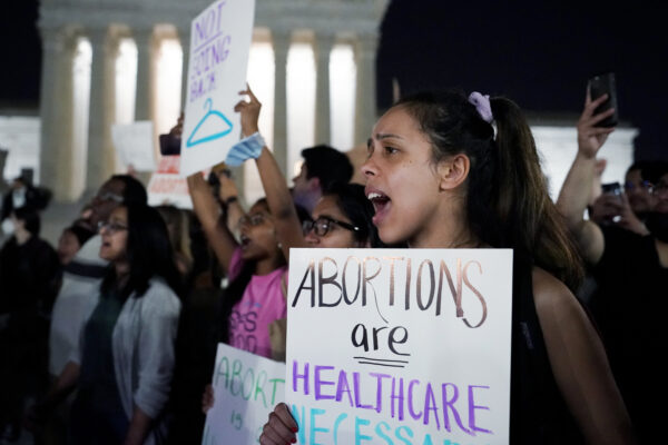 Demonstrators carrying signs with slogans like "abortion is health care"
