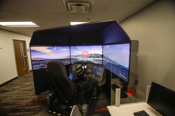 A driving simulator with a steering wheel in front.