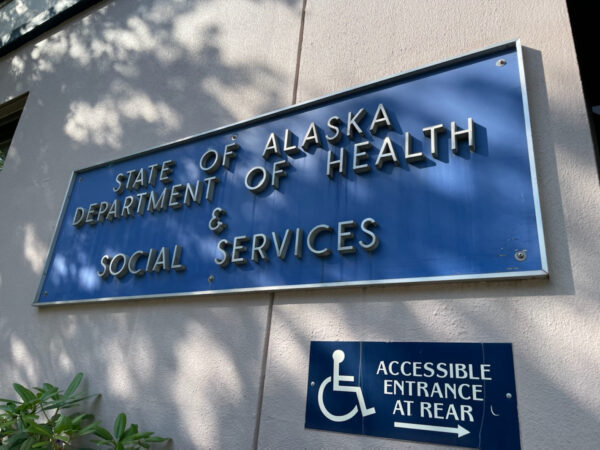 a blue sign on the side of a building says "State of Alaska Department of Health and Social Services"