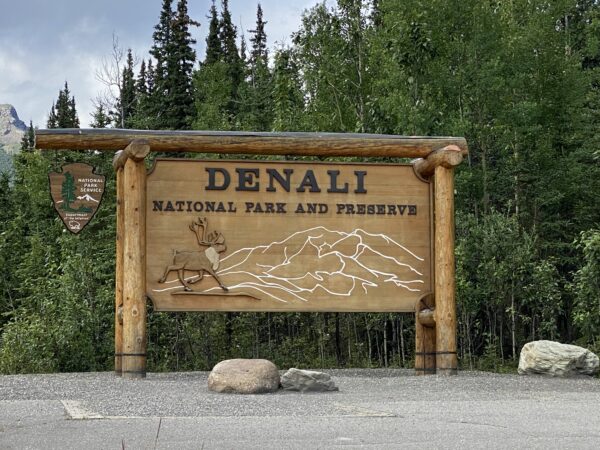 A wooden outdoor sign says "Denali National Park and Preserve"