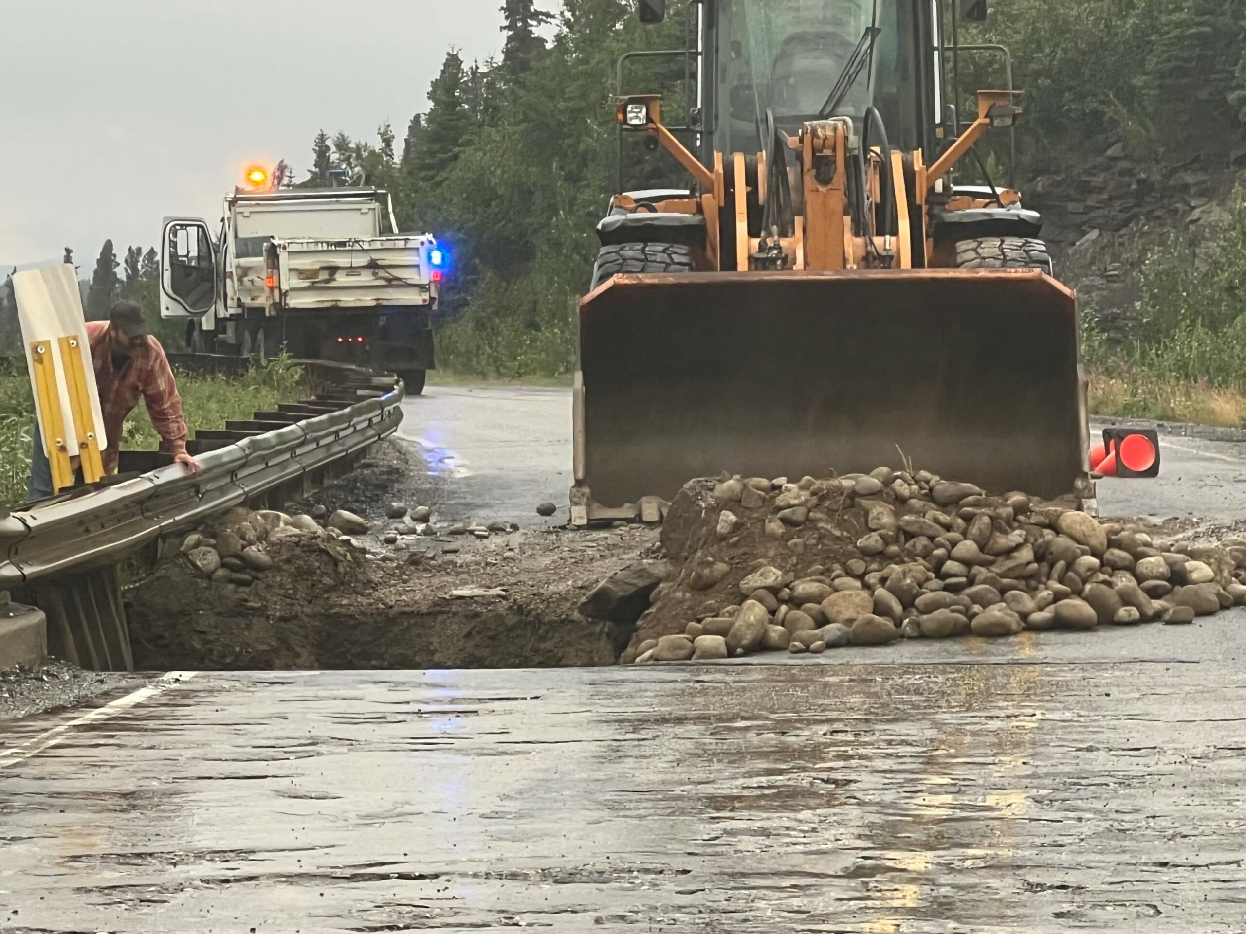 a bulldozer pushes rocks on a roadway