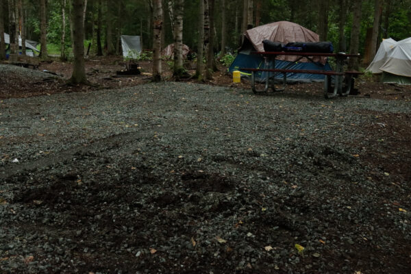 A dirty road with a tent in the background