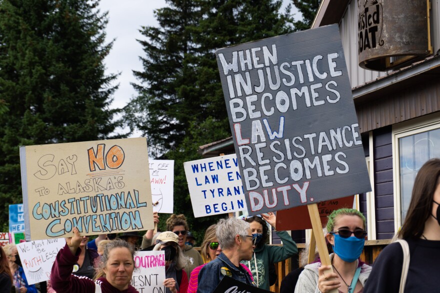 Protesters hold signs saying "When injustice becomes law, resistance becomes duty"