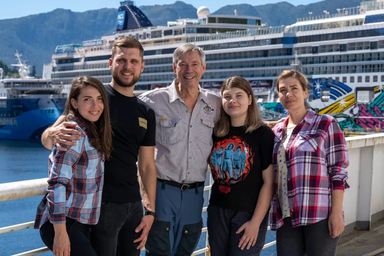 A group of smiling people pose aboard a retired Alaska Marine Highway ferry.