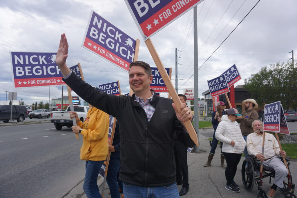 a man with a sign that says "Nick Begich for Congress" surrounded by people with similar signs