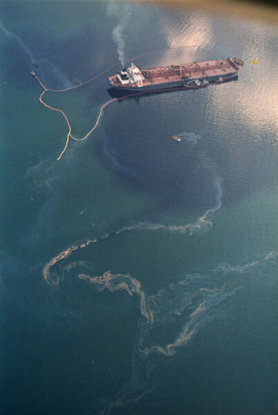 oil spills out near a tanker in the ocean
