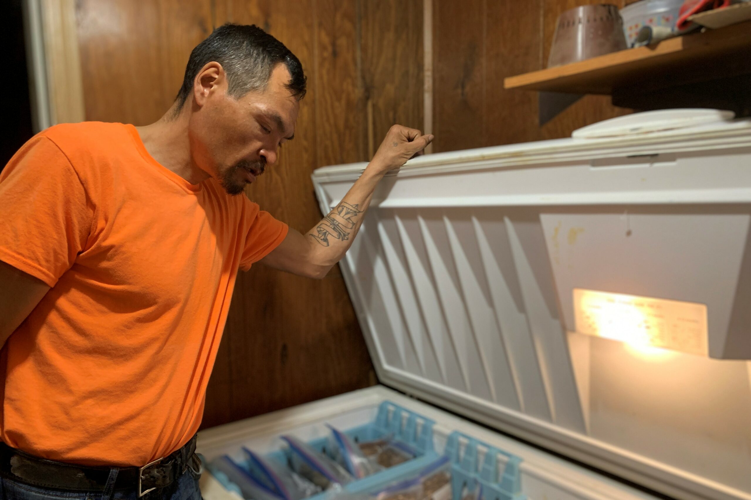 a man looking into a freezer