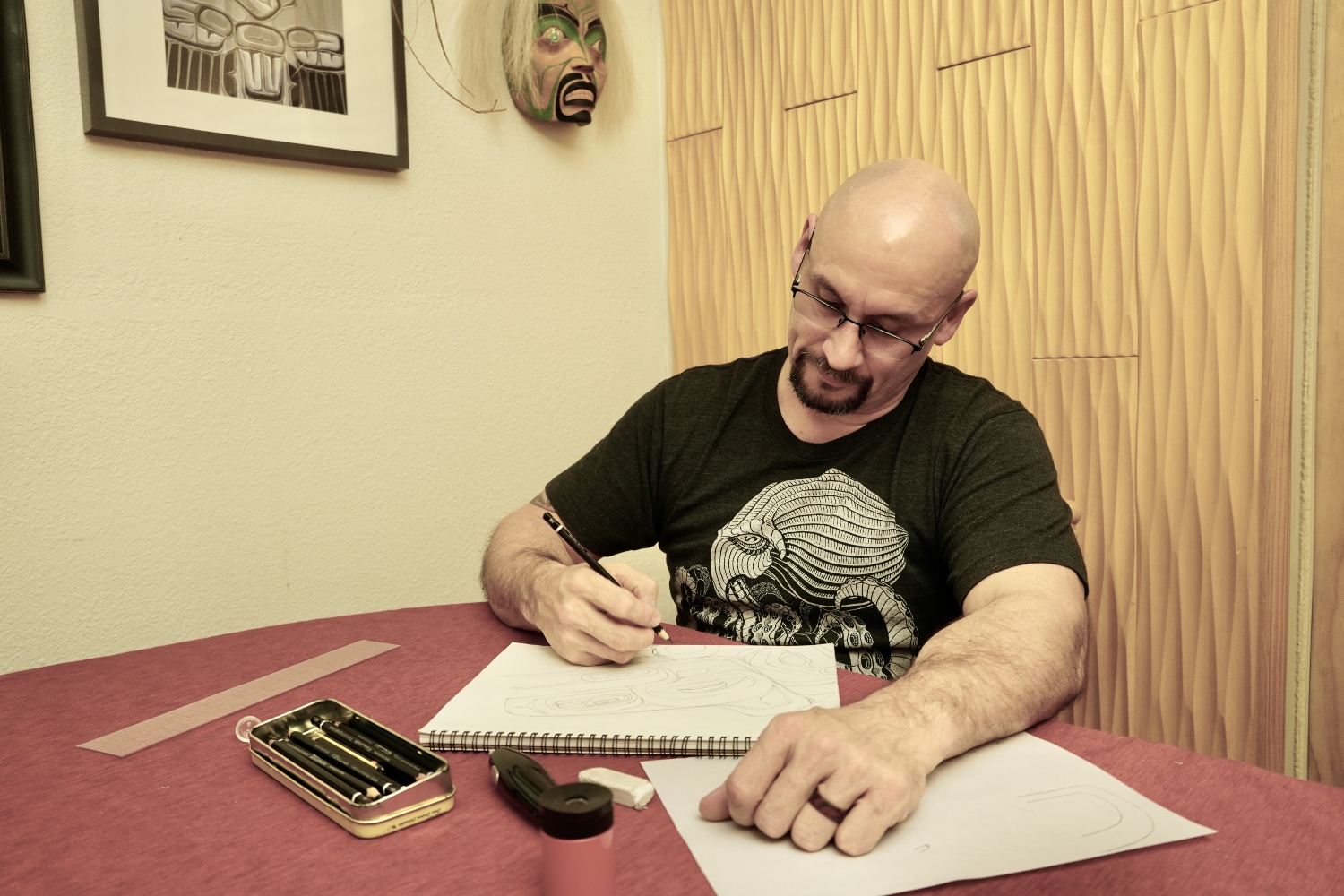 a man writes at a table inside