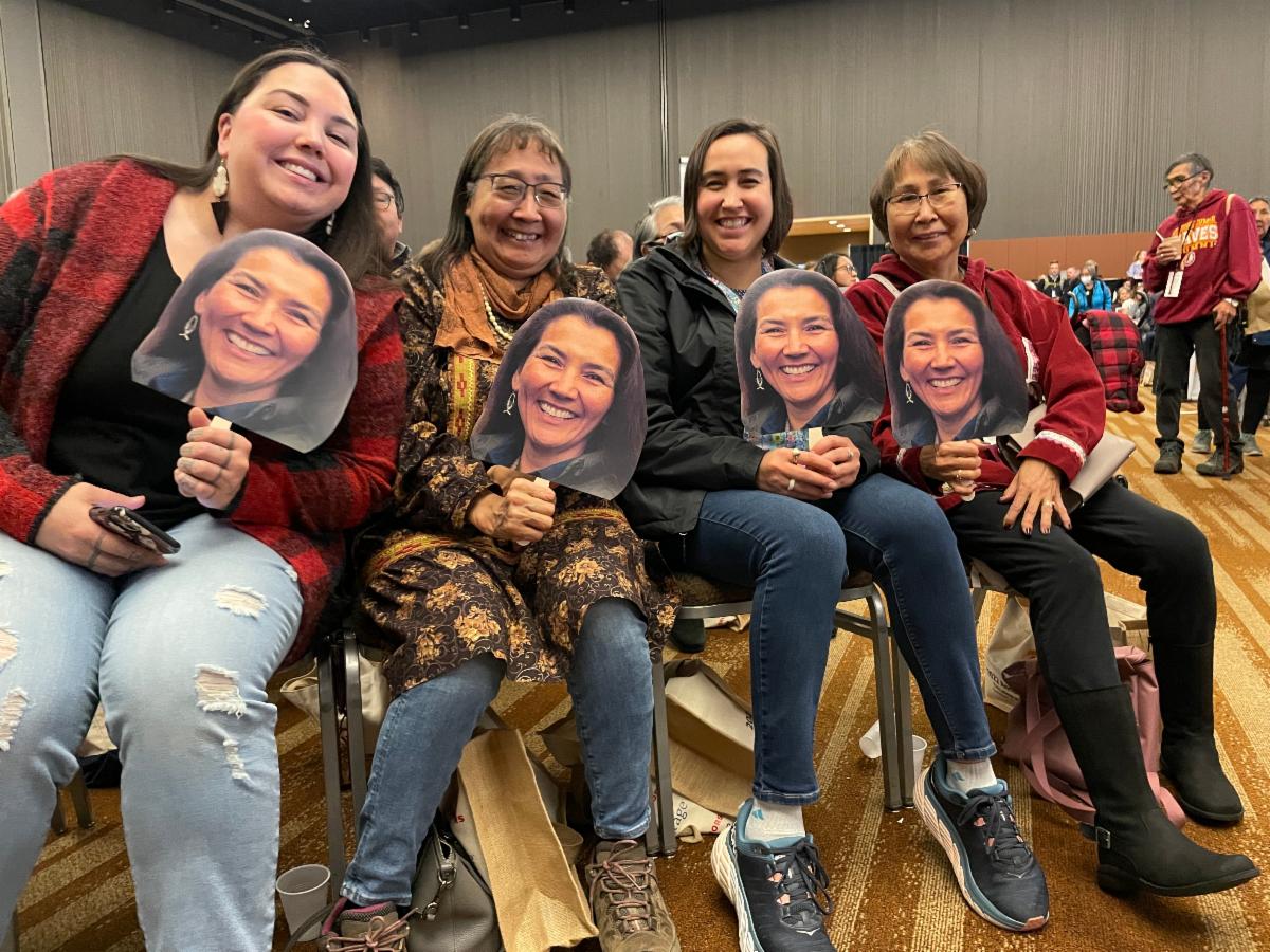 a group of people with fans with a woman's face on them