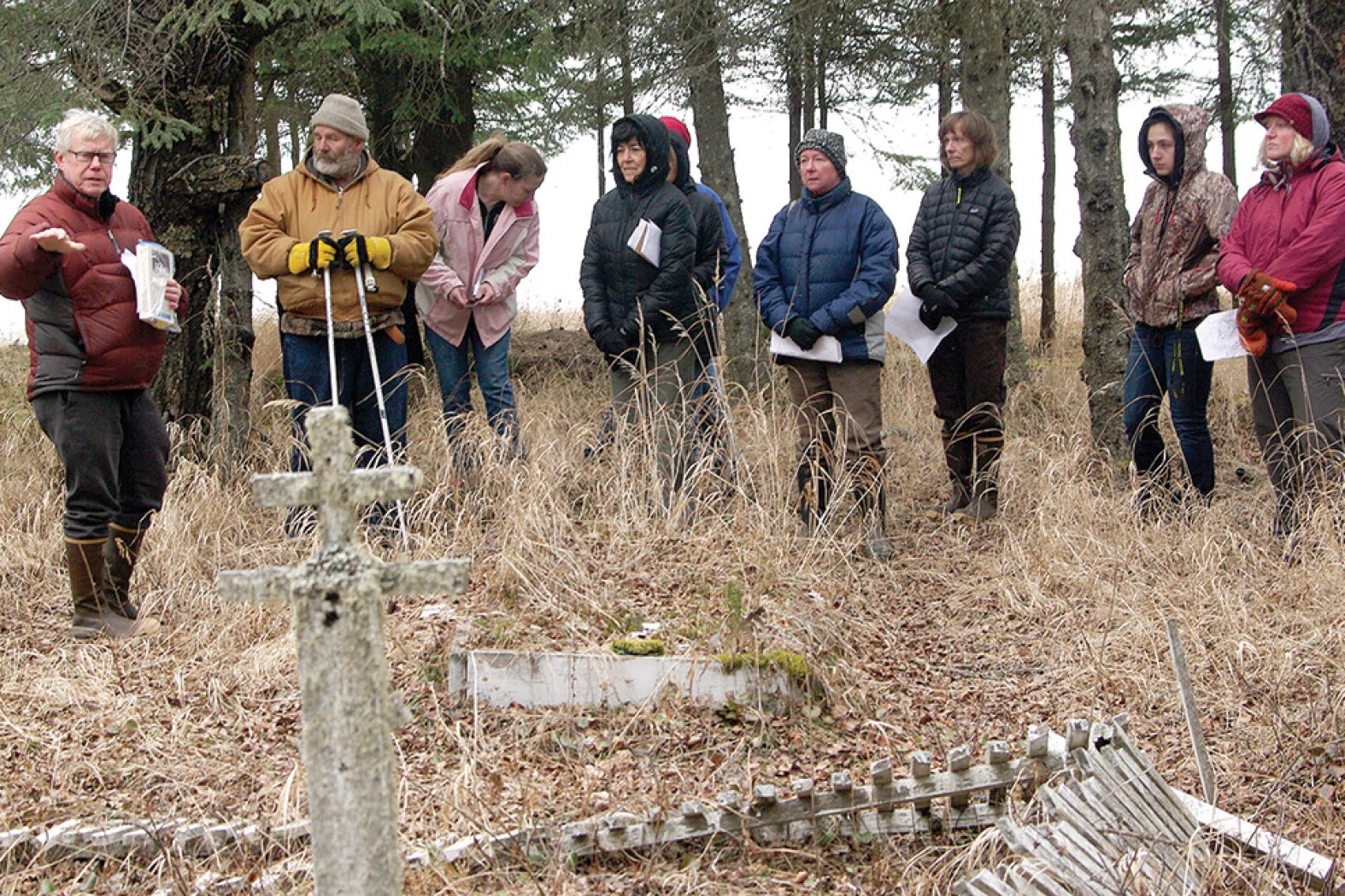 people stand at a gravesite outside