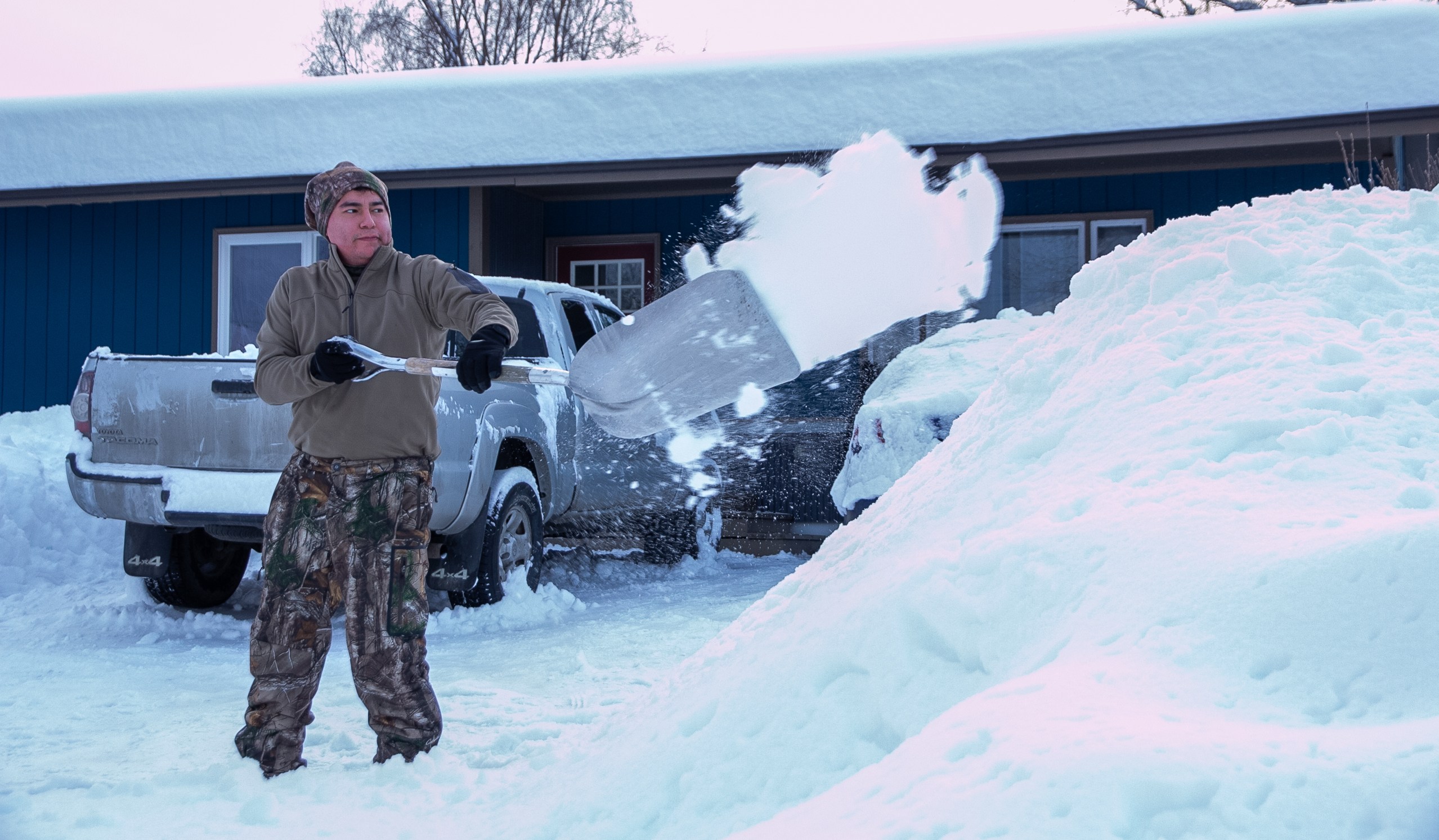 A man shovels snow into a pile.