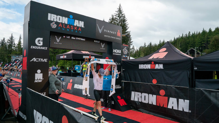 a person crosses a finish line that says Ironman Alaska