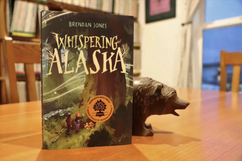 A book called "Whispering Alaska" next to a bear