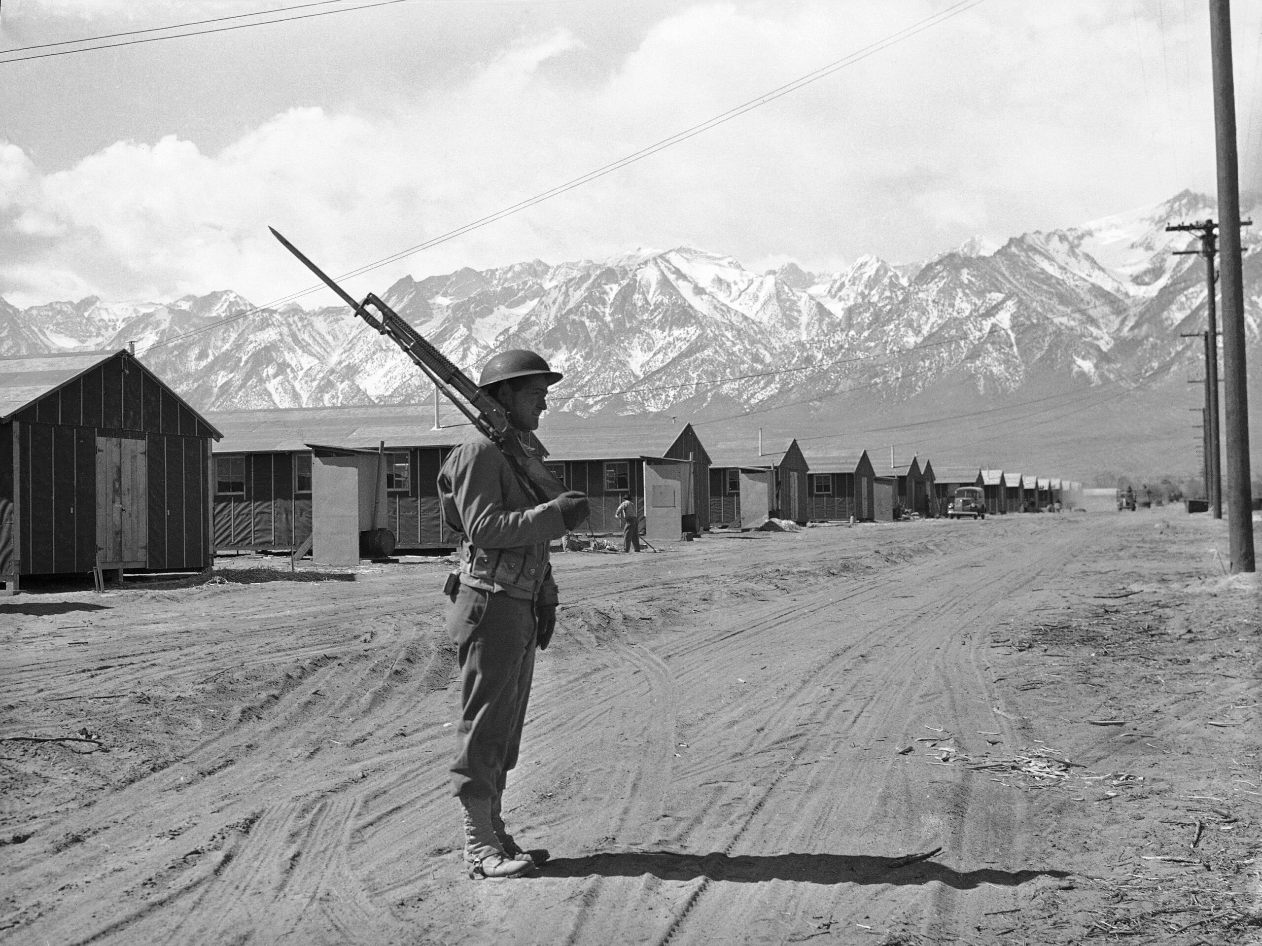a soldier guards a World War II Japanese detainee camp