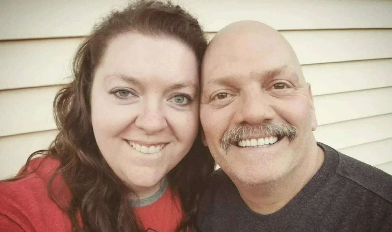 a man and woman pose, smiling, for a selfie