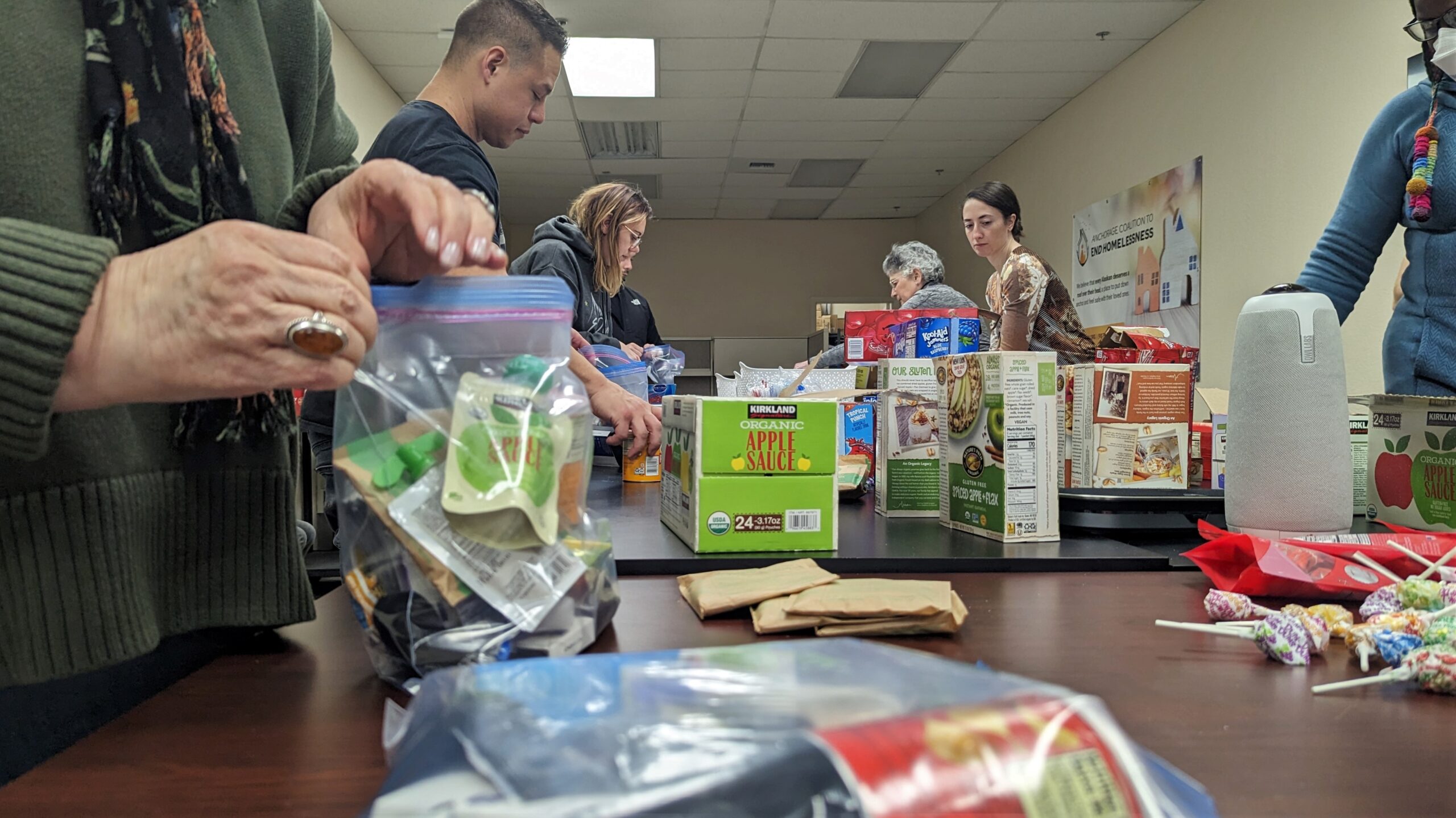 volunteers put together baggies of personal hygiene products and snacks