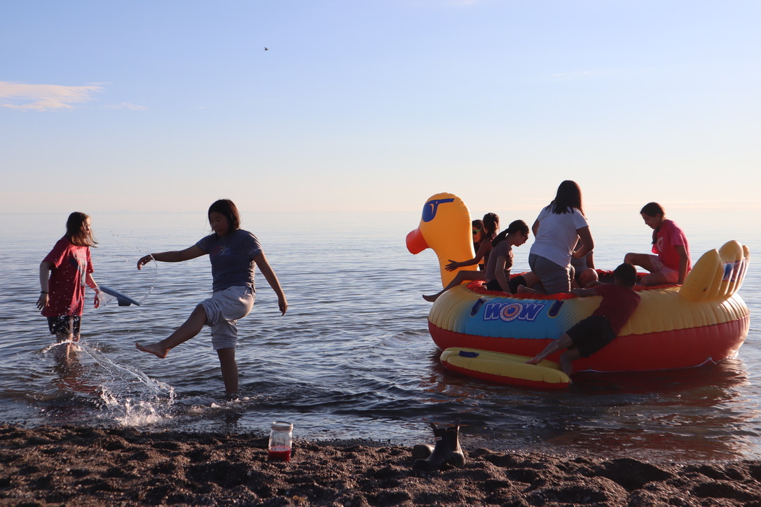 children play on a big blowup in the ocean
