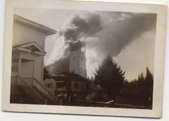 a grayscale photo of a church on fire