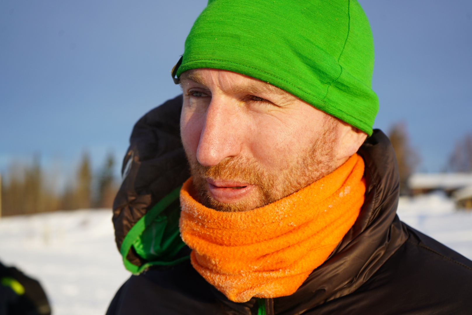 a man in a green hat and orange buff