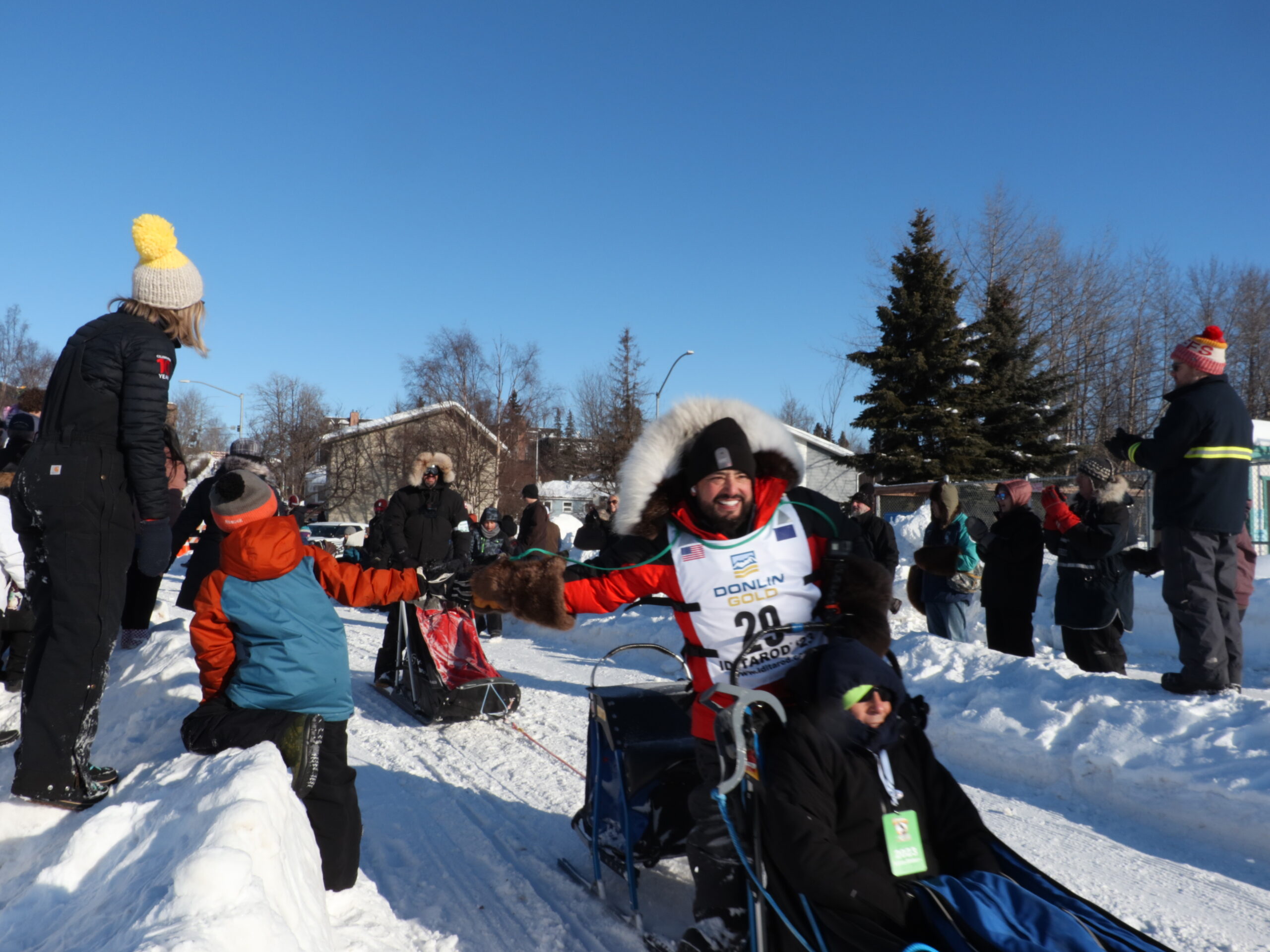 a kid gets a high five from a musher