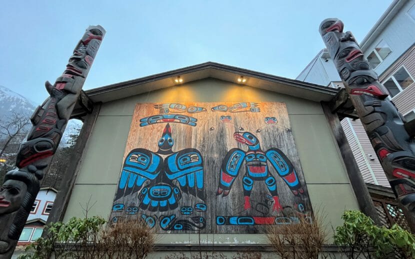 a Tlingit mural and totem poles
