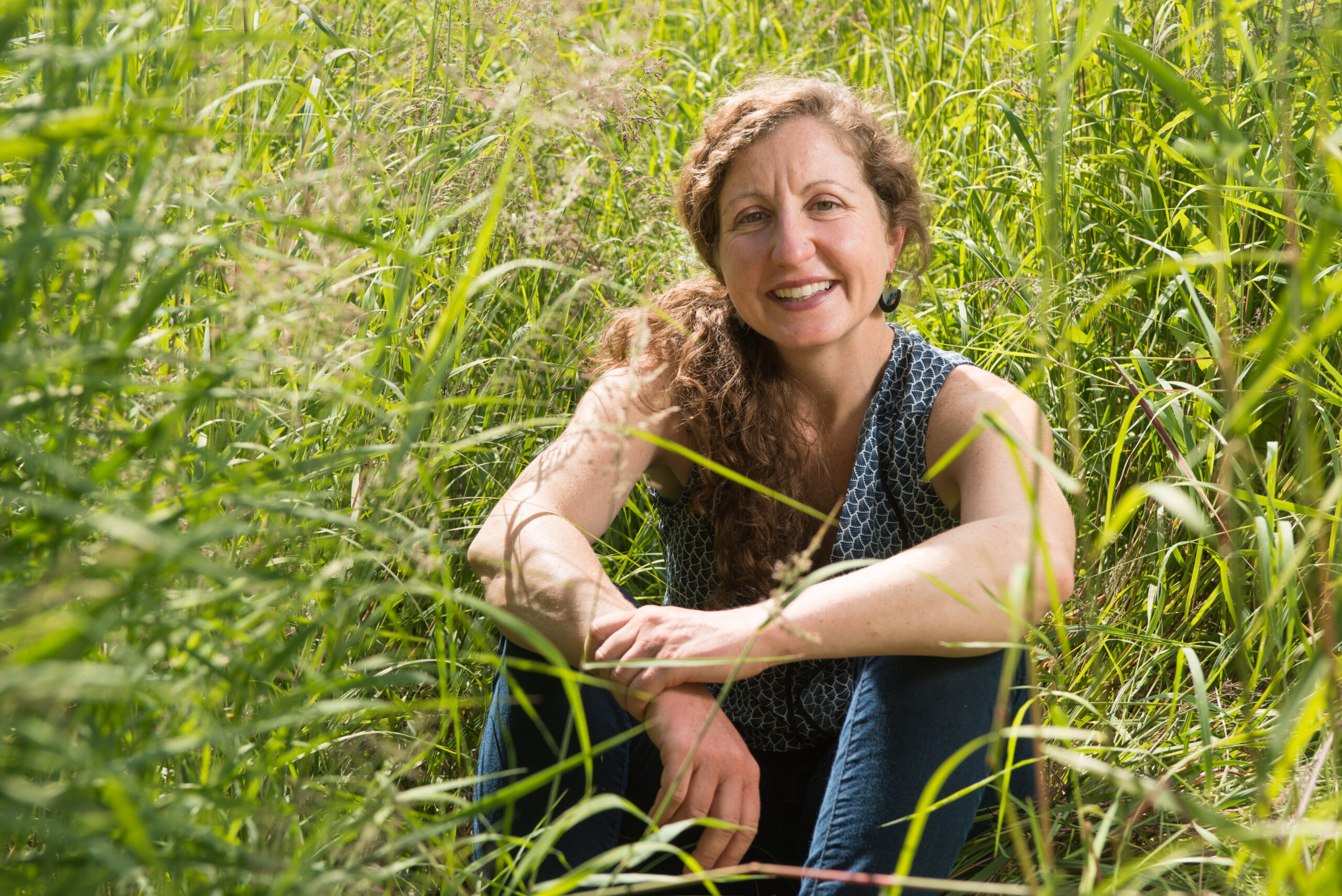 A woman sits in a field of grass