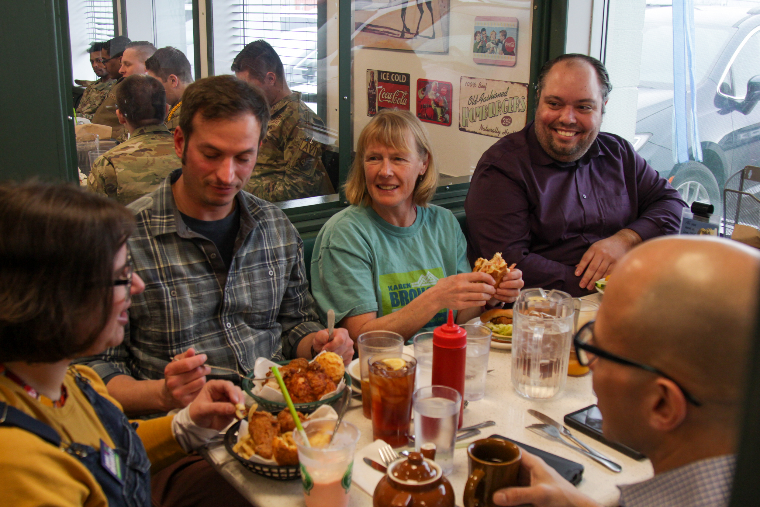 Over a crowded diner table, a group of adults talk and laugh.
