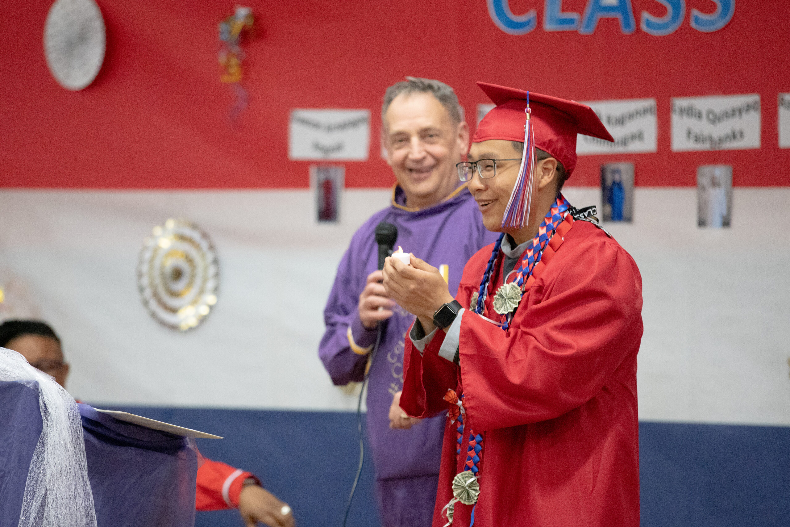 A young Yup'ik man smiles in his graduation cap and gown.