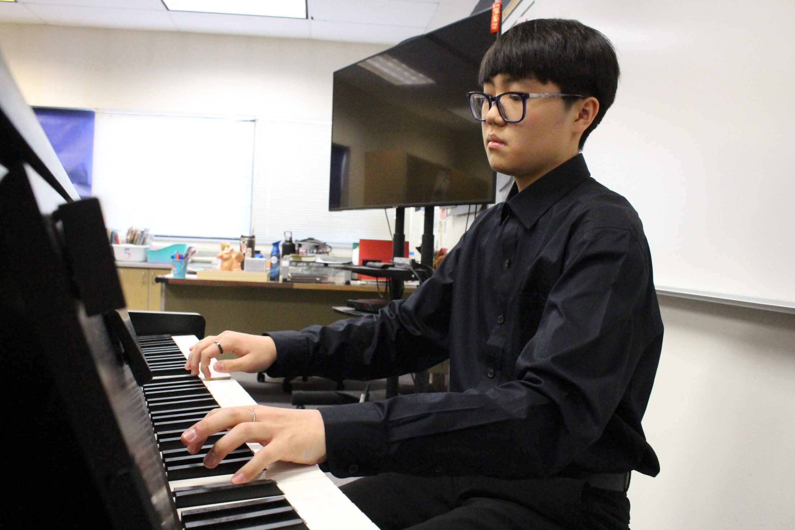 A middle school musician plays piano