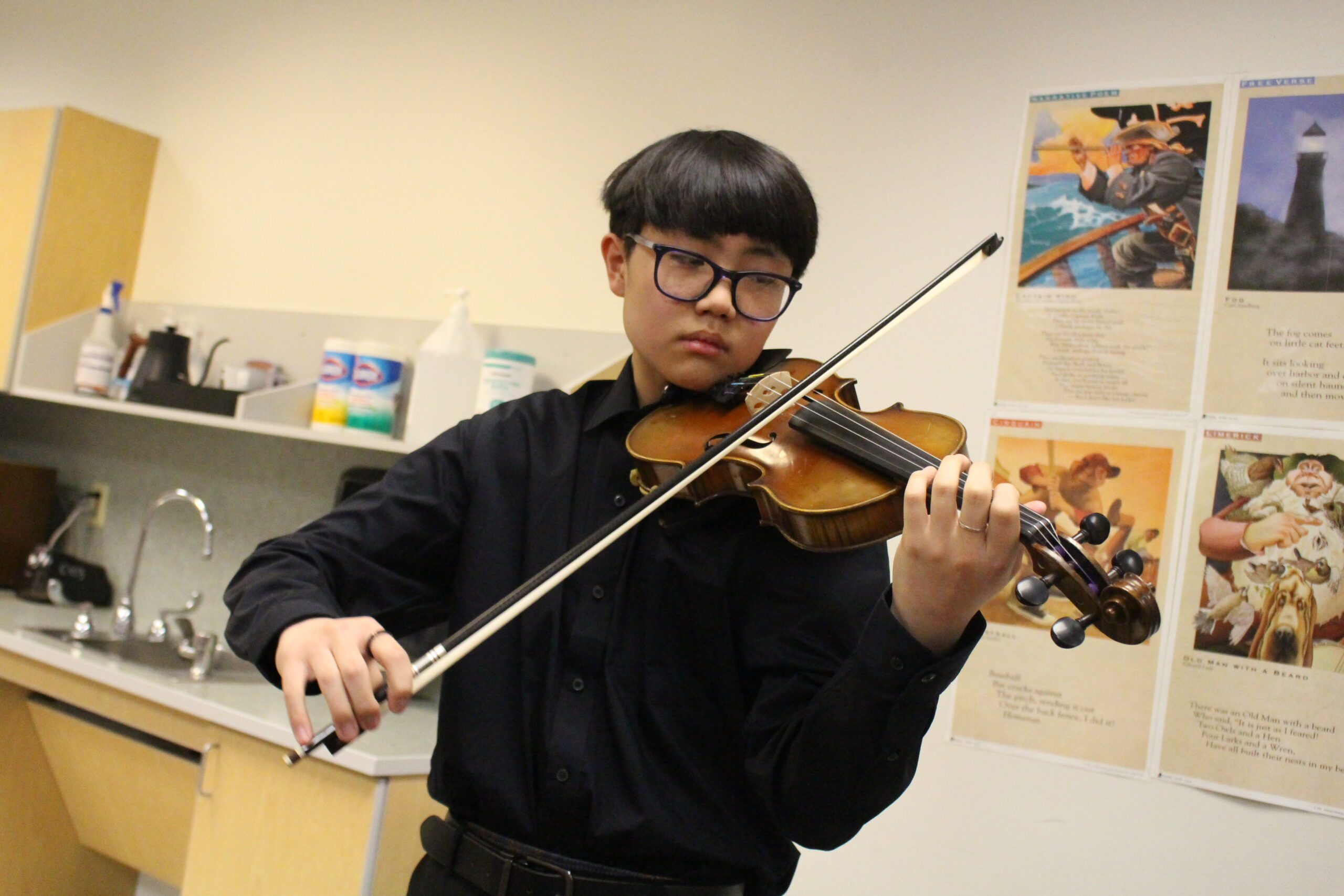 A middle school musician plays violin.