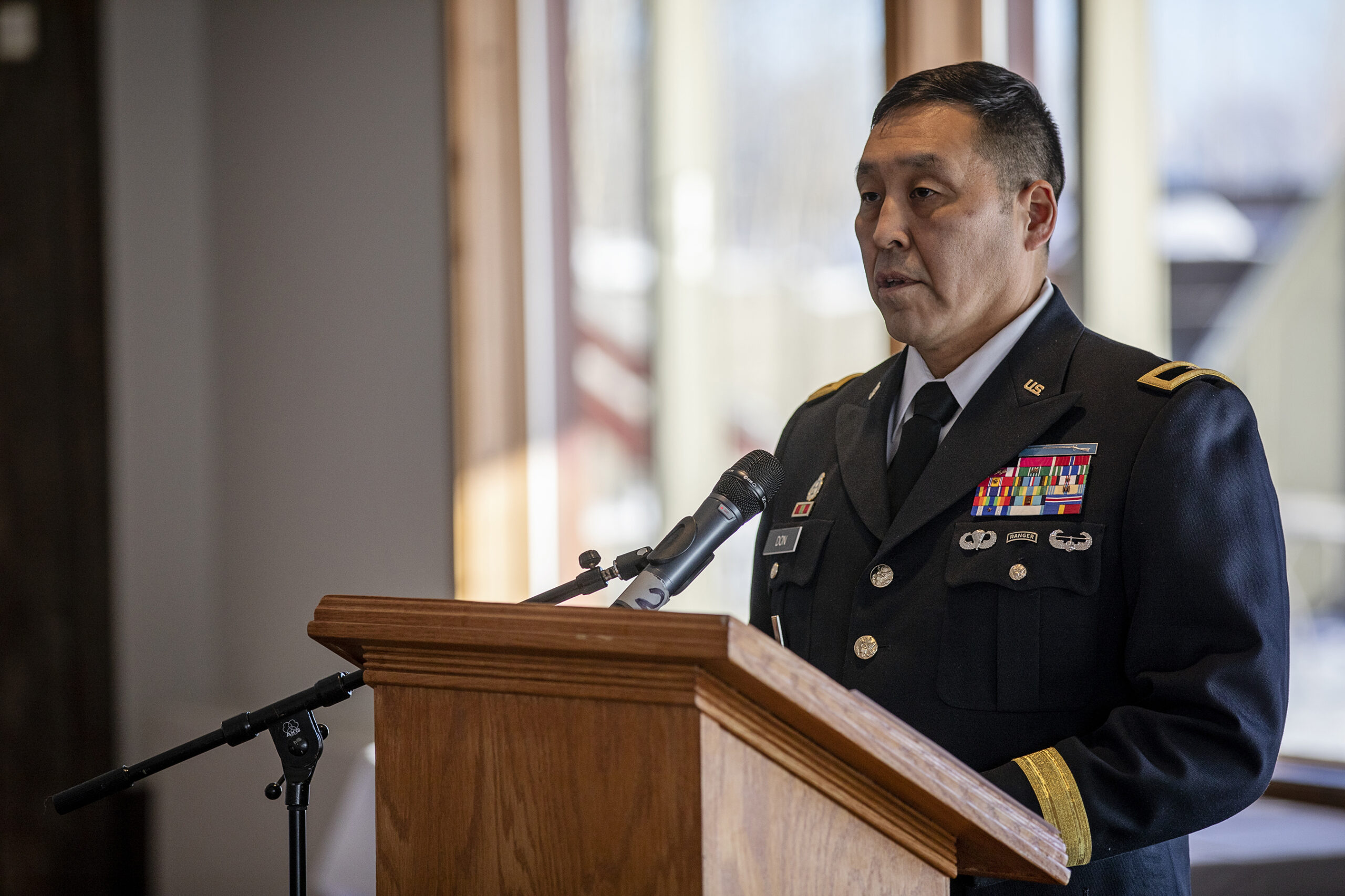 A man in a military uniform speaks at a podium