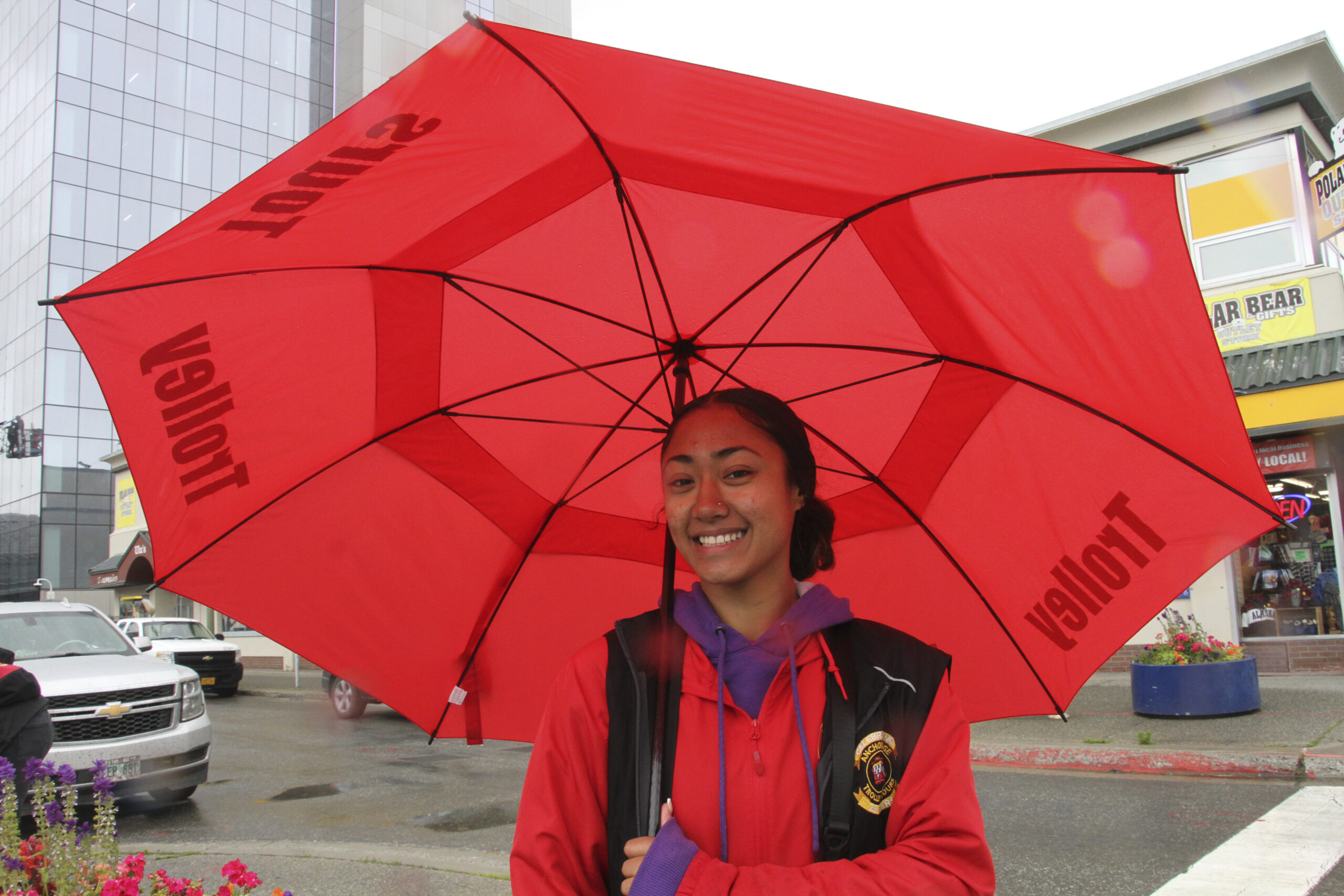 a woman outside in the rain with a big red umbrella