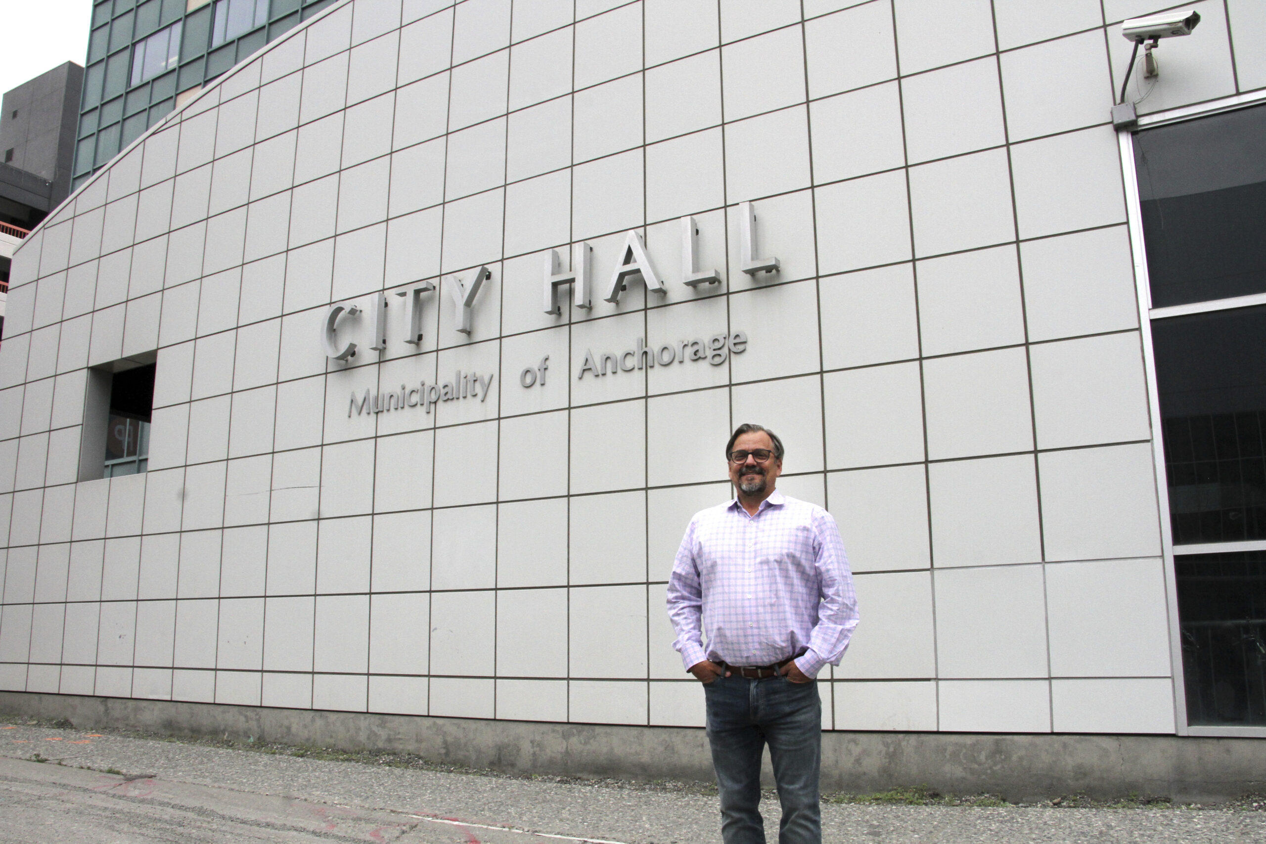 a man poses for a photo in front of city hall