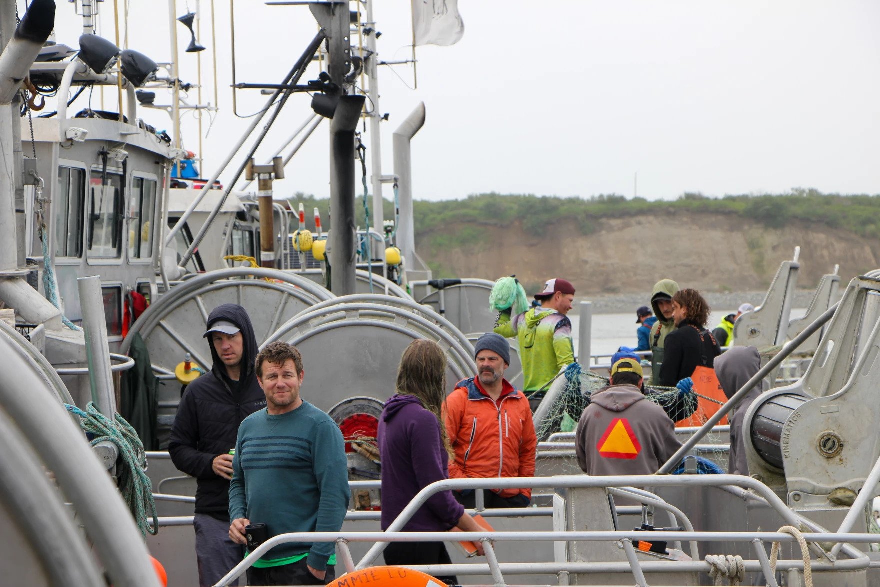 people stand on a fishing boat