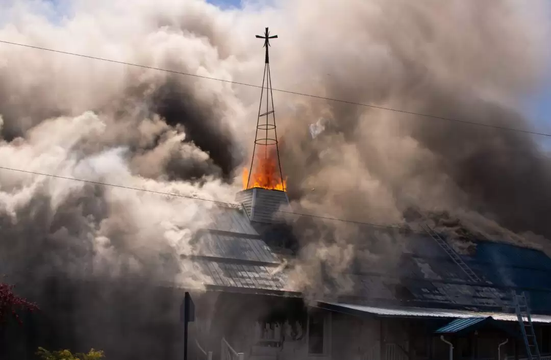 smoke billows around a church steeple