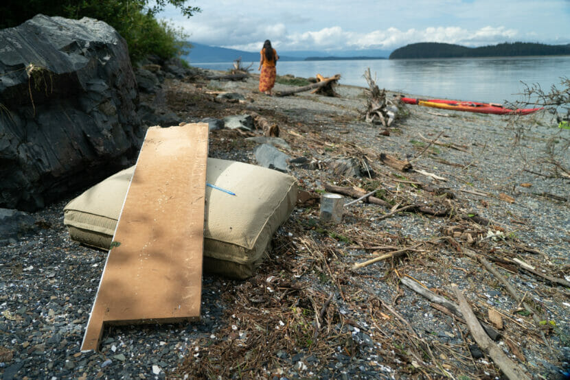 a pillow and other debris washed on a rocky beach