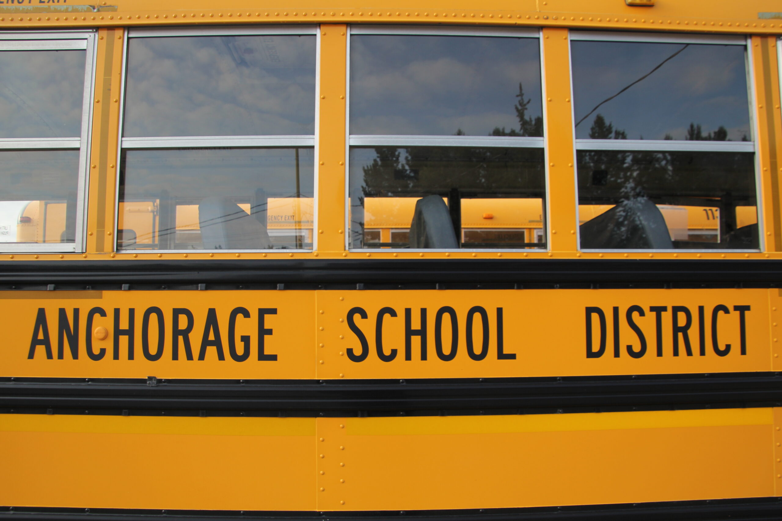 The side of a yellow school bus that says "Anchorage School District"