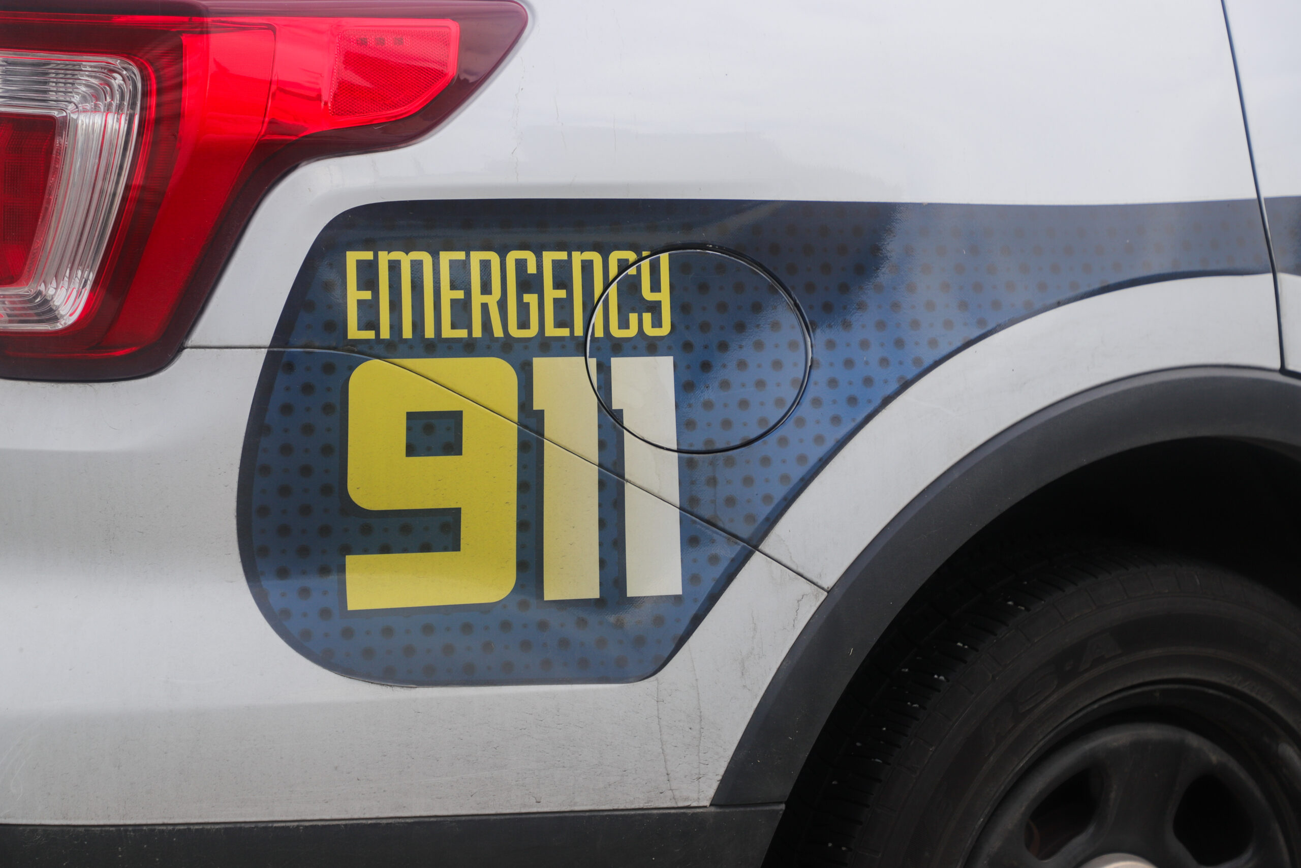 close up of a police car, it reads "Emergency 911."