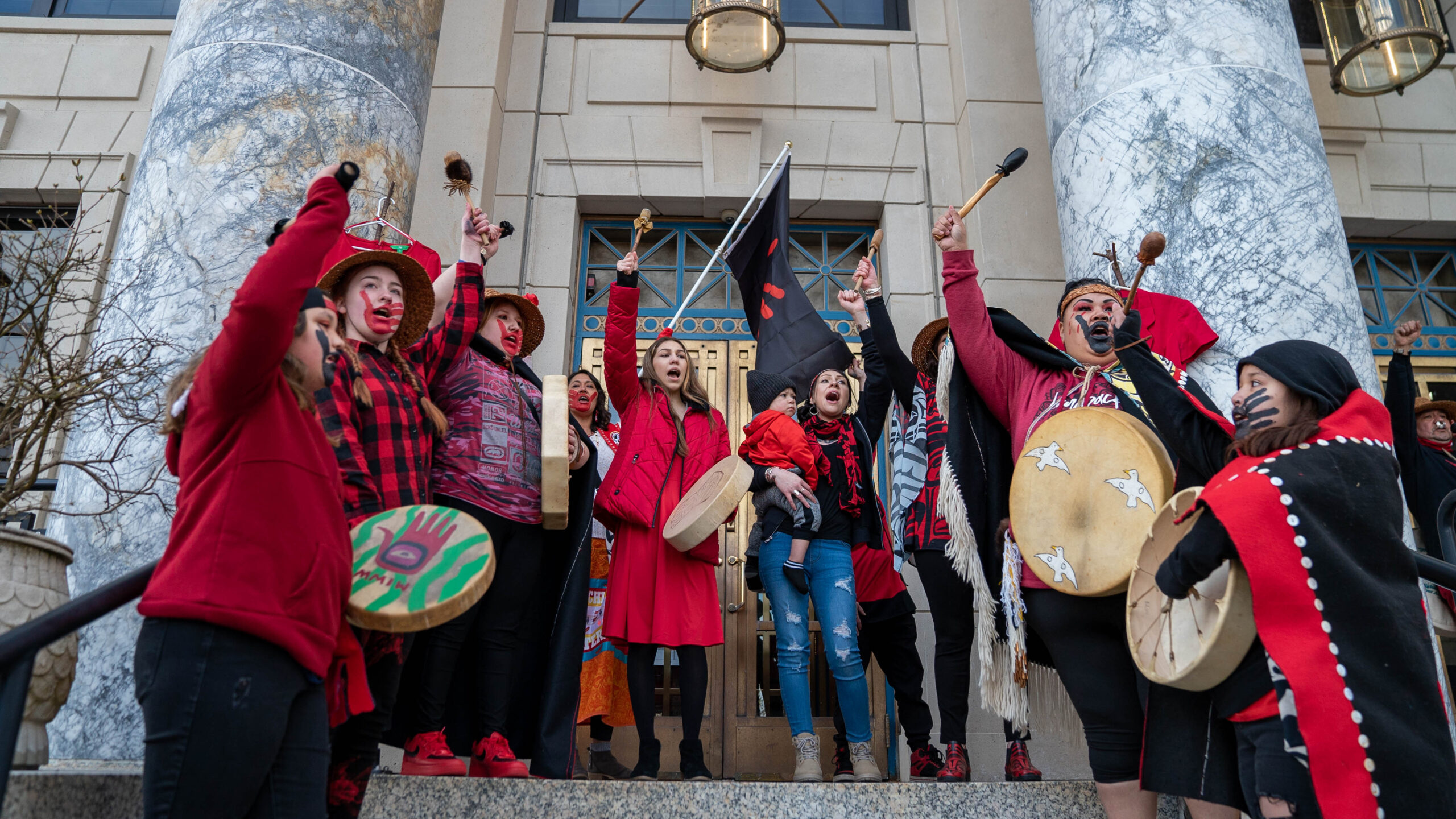 a group singing in front of the Alaska Capitol