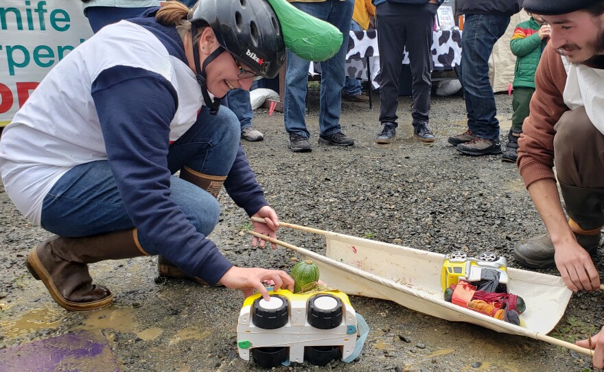 two people put toy cars on a stretcher