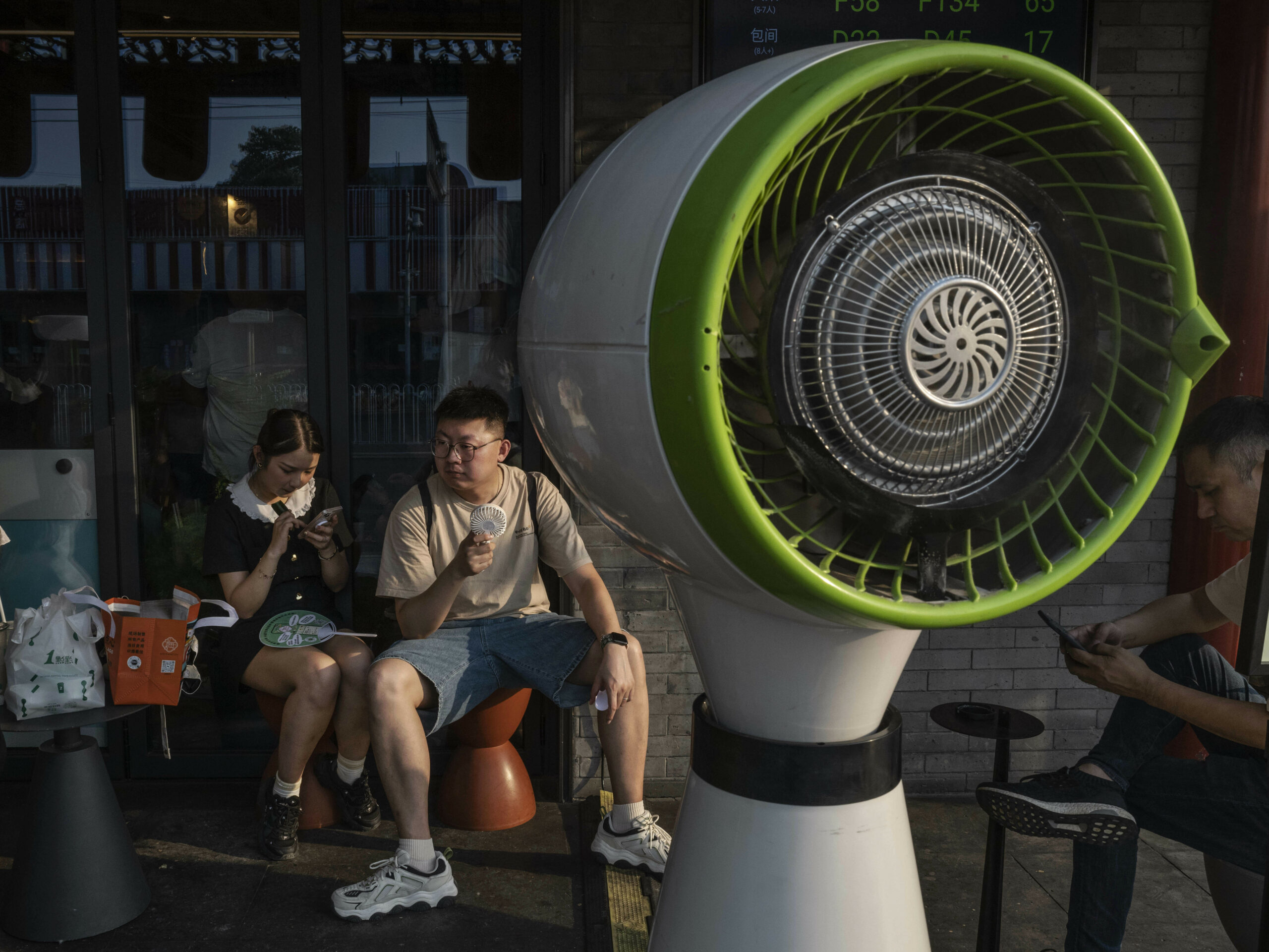 people sit near a fan