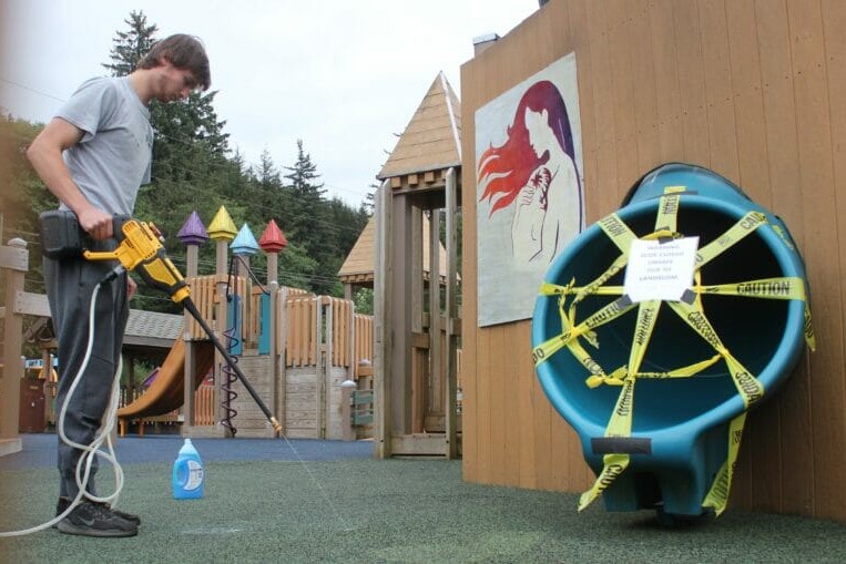 a person washes playground equipment with a power washer