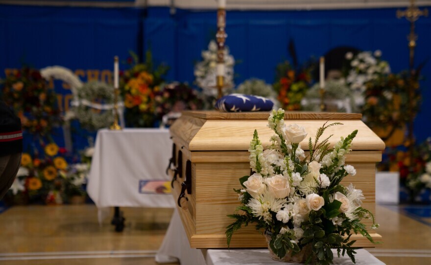a wooden casket surrounded by flowers