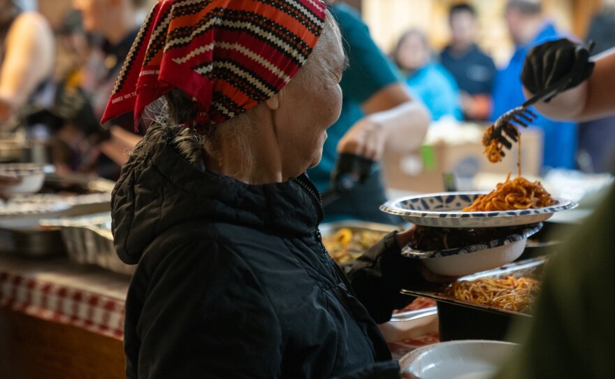a woman in a bandana is served food