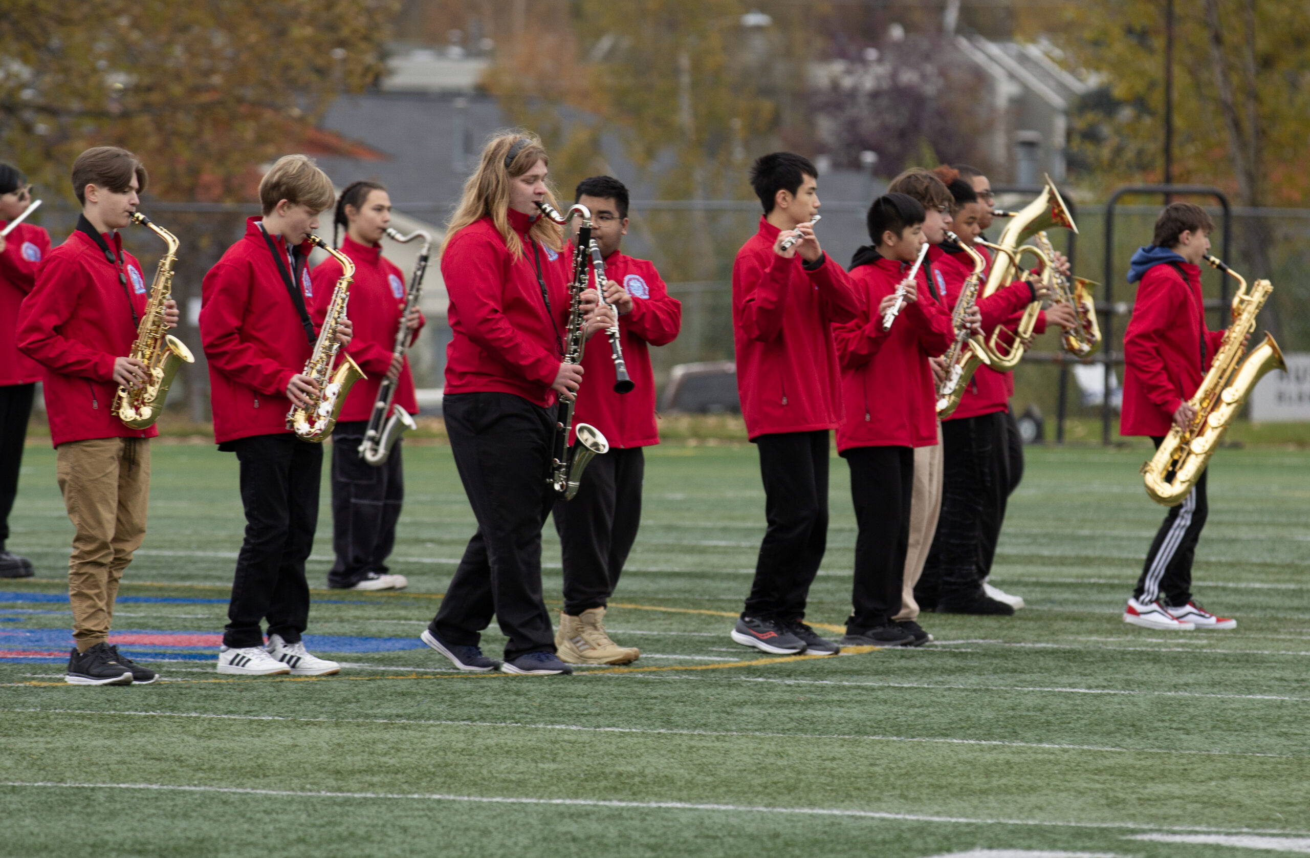 Students in red jackets march and play instruments at Bettye Davis East High School on Sept. 30, 2023 (Shiri Segal/Alaska Public Media)