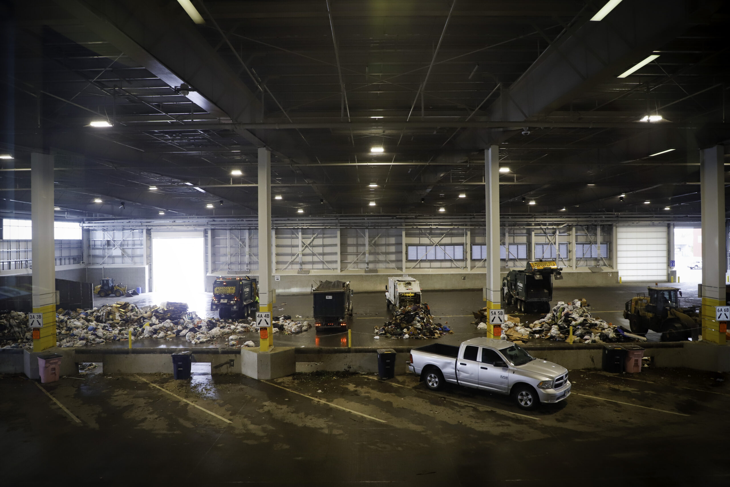 A view of the tipping floor from the observation deck of waste services dumping waste onto the floor.