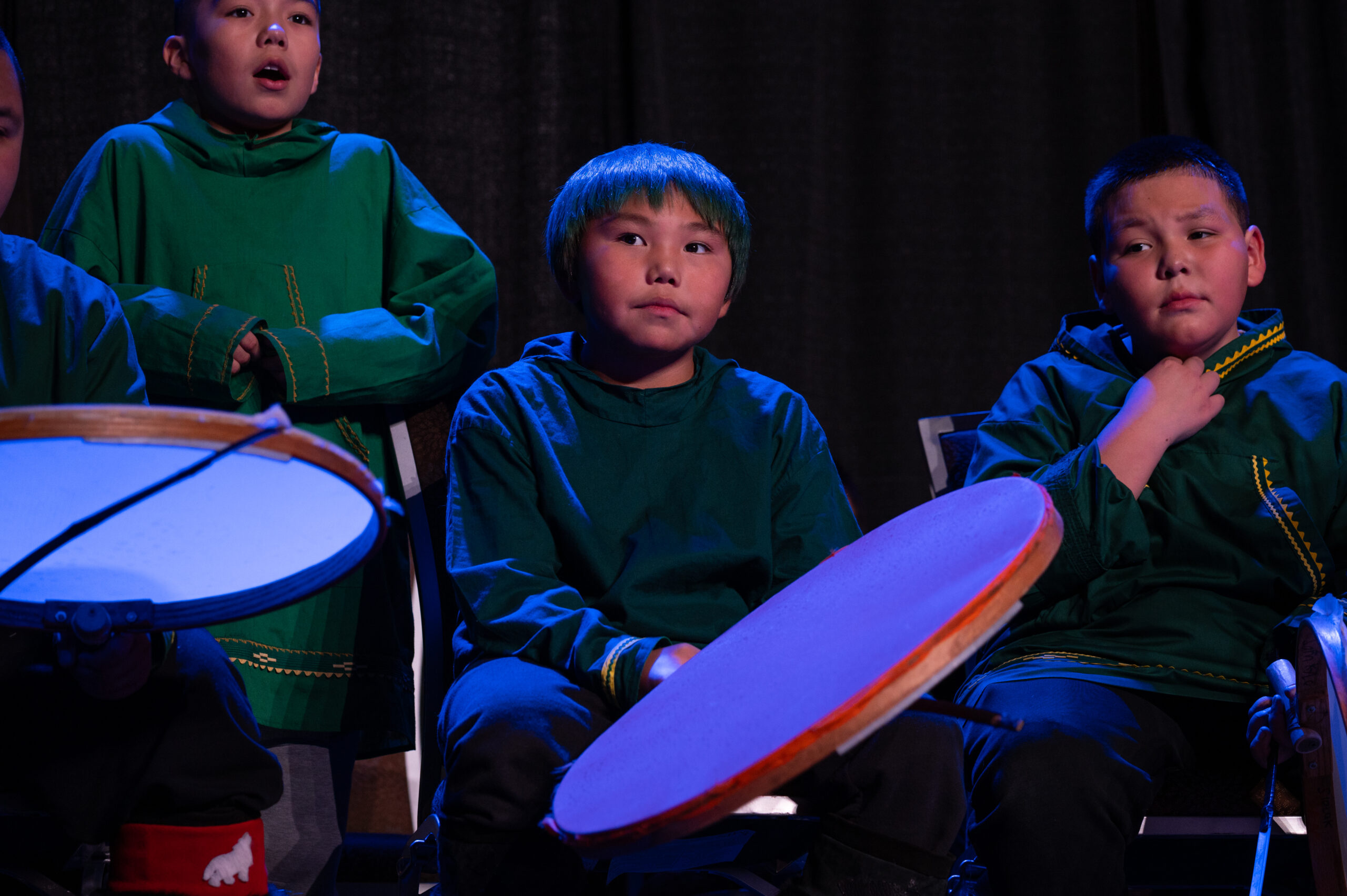 A group of boys sitting with native drums