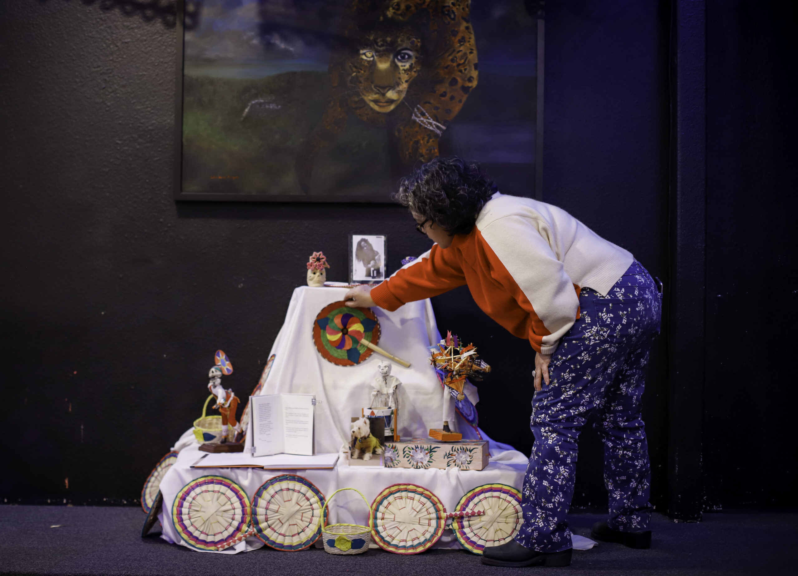 A lady places a fan on a white covered altar.